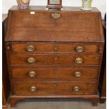 A Georgian oak bureau, the fall front opening to reveal an interior of drawers and pigeon holes