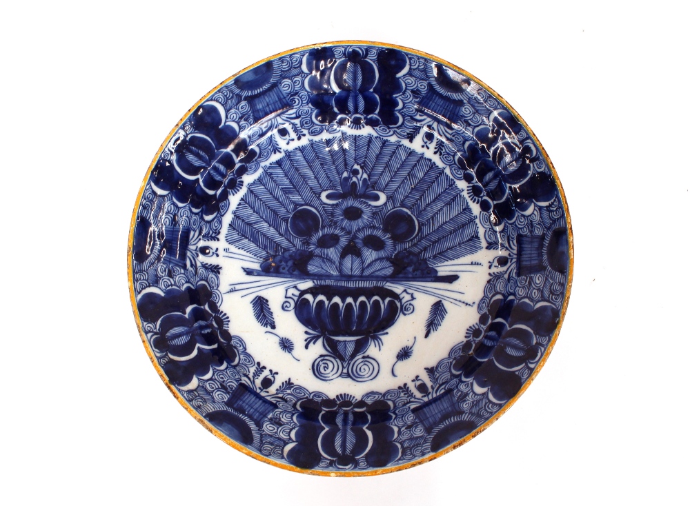 A pair of Delft shallow dishes, decorated central vase of flowers and foliate borders, 31cm