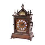 An ornate brass cased mantel clock, with eight day movement striking on a bell, circular foliate