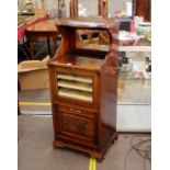 An Edwardian mahogany music cabinet, the raised mirror back surmounted by a three quarter pierced