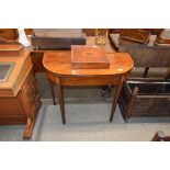 A George III mahogany and rosewood cross banded D shaped fold over card table, raised on square