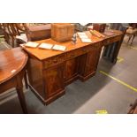 A 19th Century mahogany writing desk of breakfront form, central cupboard flanked by smaller