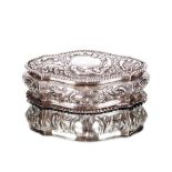 An Edwardian silver oval trinket box, with embossed foliate decoration, the hinged lid  AF with