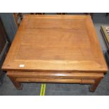 An oriental elm low table, raised on shaped square supports united by stretchers, 90cm