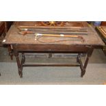 An antique oak side table, planked top above two end drawers raised on turned baluster supports