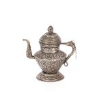 A Tibetan white metal butter teapot, having foliate embossed decoration, 16cm high