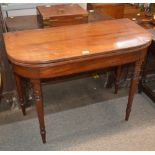 A Georgian mahogany D shaped card table, the fold over top raised on turned tapering supports, 99cm