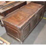 A 17th Century oak coffer, triple panelled lid and front with carved decoration, 131cm wide