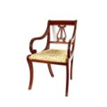 A pair of Regency style mahogany elbow chairs, with lyre backs, reeded scroll arms and sabre