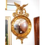 A Regency style gilt convex wall mirror, with eagle surmount and ball decoration above acanthus
