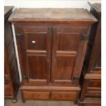 An 18th Century oak press cupboard, the interior hanging compartment enclosed by a pair of quarter