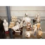 A collection of antique Oriental carved ivory figures including Netsuke, and some later resin