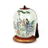 A Chinese ginger jar, decorated with a scene of figures in an exotic garden with wooden lid,