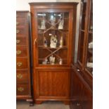 An early 20th Century mahogany floor standing corner cabinet, the upper display shelves enclosed