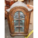 An antique walnut freestanding dwarf corner cupboard, the shaped interior shelves enclosed by a