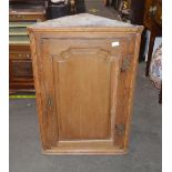 A 19th Century light oak hanging corner cupboard, enclosed by a single fielded panel door, 64cm x