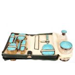 A silver and blue enamel Art Deco part dressing table set, the brushes and mirror contained in a