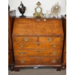 An antique oak bureau, the fall front revealing a fitted interior arrangement of drawers and
