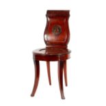 A pair of George III Irish mahogany hall chairs, the shaped backs with Greek key motifs and
