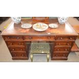 A Victorian mahogany kneehole writing desk, leather inset top above three frieze drawers, three