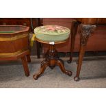 A Victorian carved walnut circular revolving piano stool