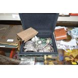 A mirrored glass trinket casket and contents of various white metal costume jewellery, bangles etc.