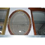 An oval gilt decorated bevel edged wall mirror