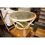 A cane and glass two tier circular table