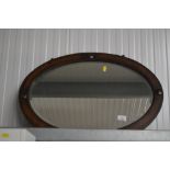 An oak framed bevel edged oval wall mirror