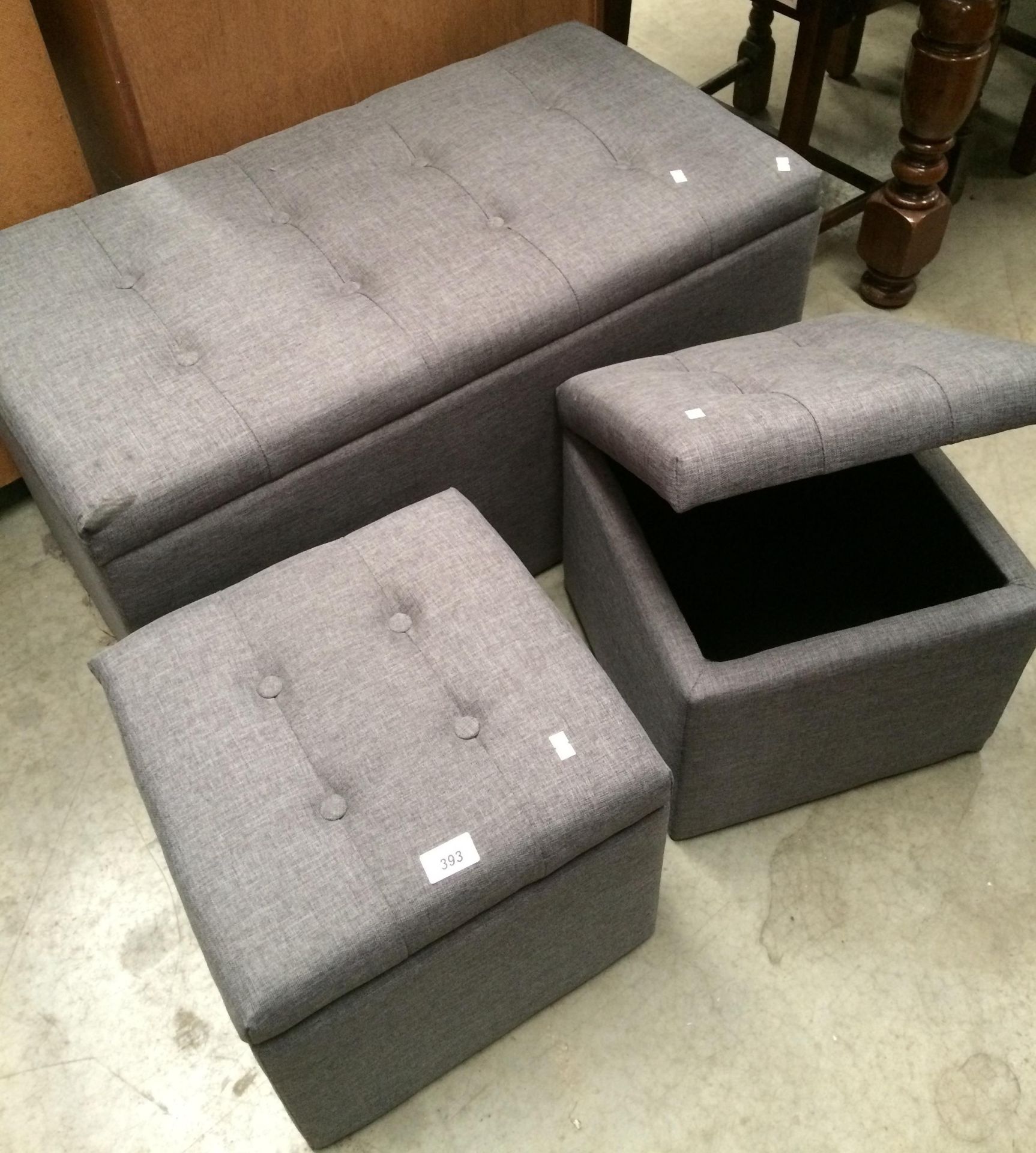 A grey cloth upholstered Ottoman and two small stools with lift up tops