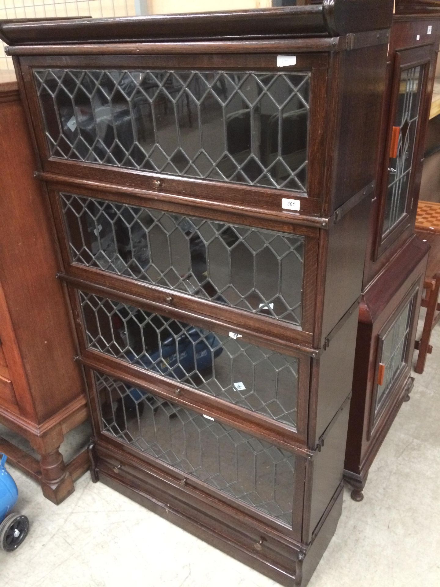A Globe Wernicke style oak bookcase with four leaded glazed lift top doors (one with slight crack)