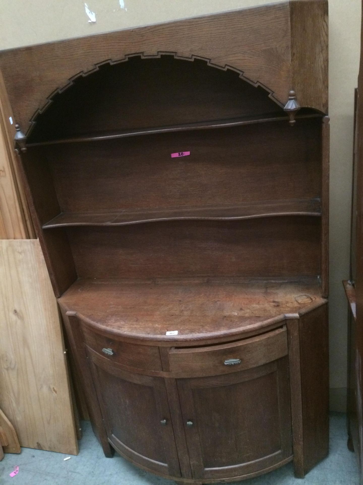 An oak bow front dresser with two open shelves over two drawer two door base 107 x 168cm high