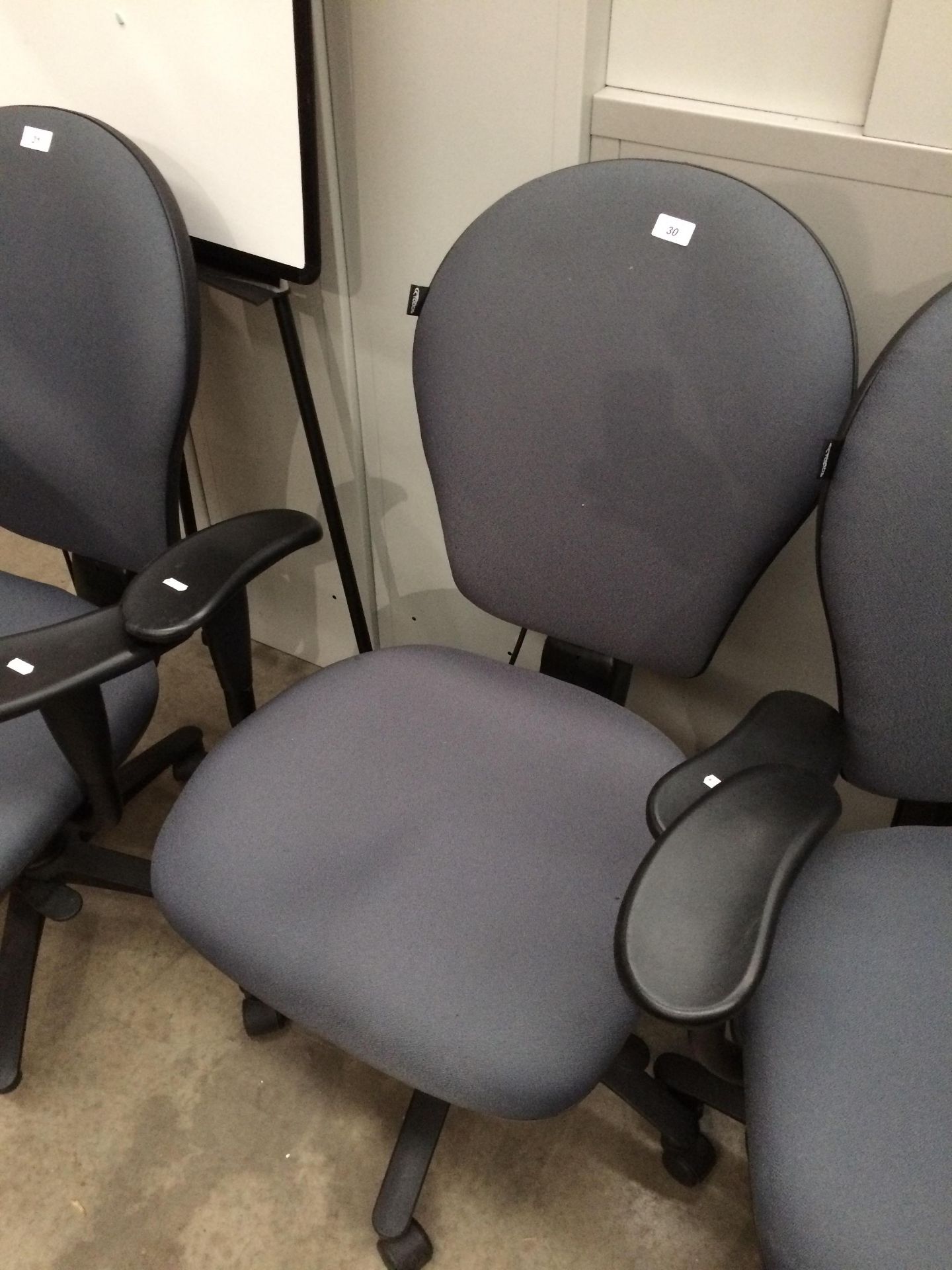 A grey upholstered office swivel armchair