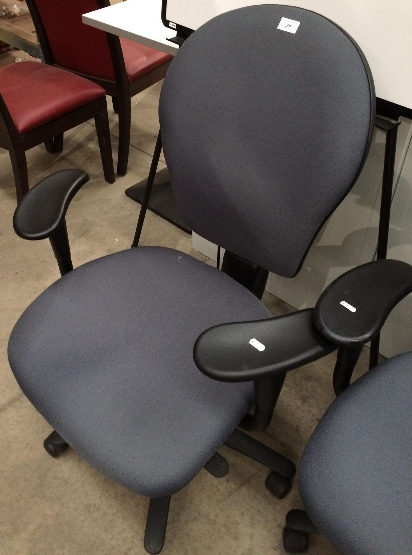 A grey upholstered office swivel armchair