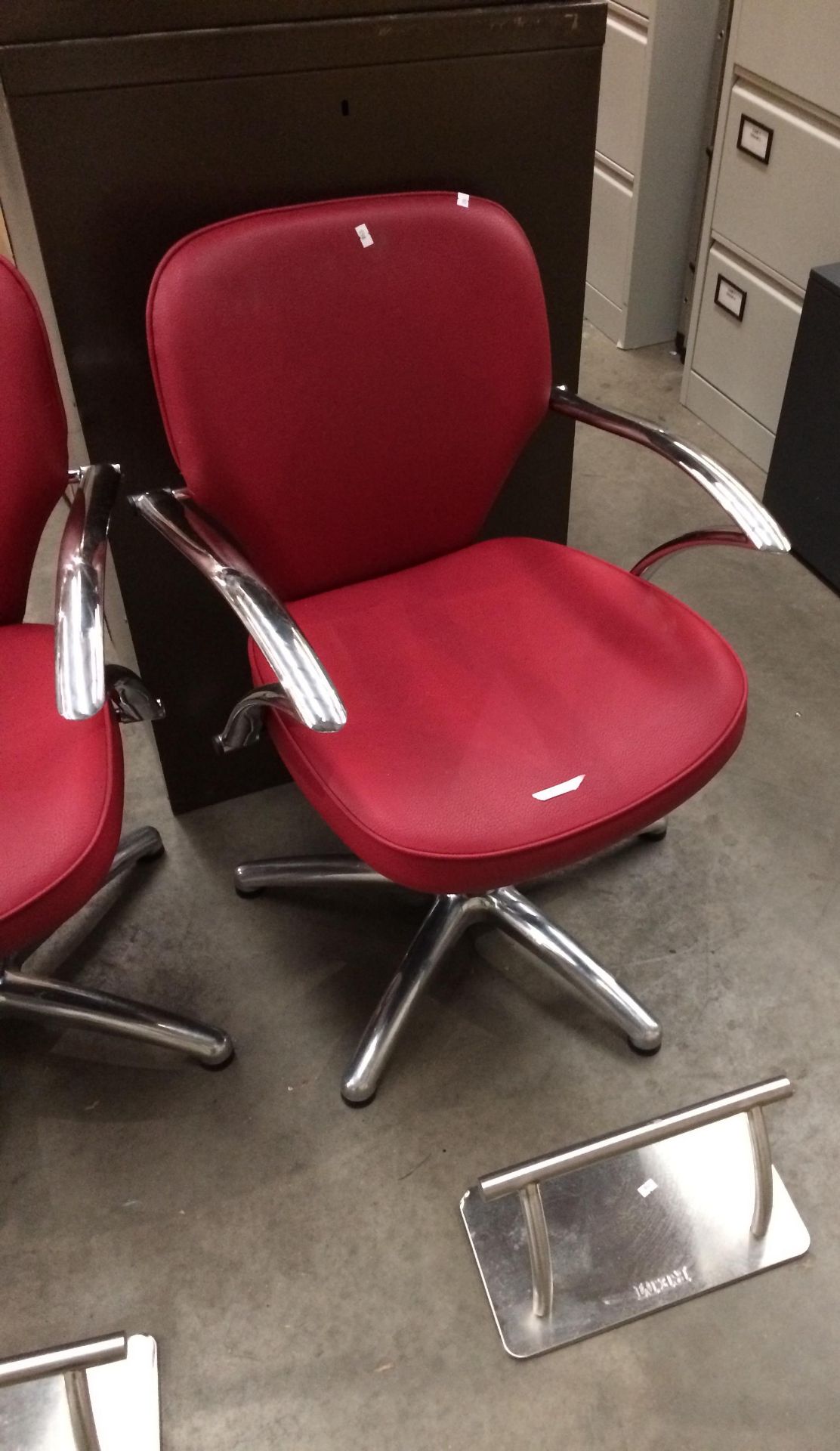 A red vinyl upholstered swivel salon armchair complete with REM foot rest