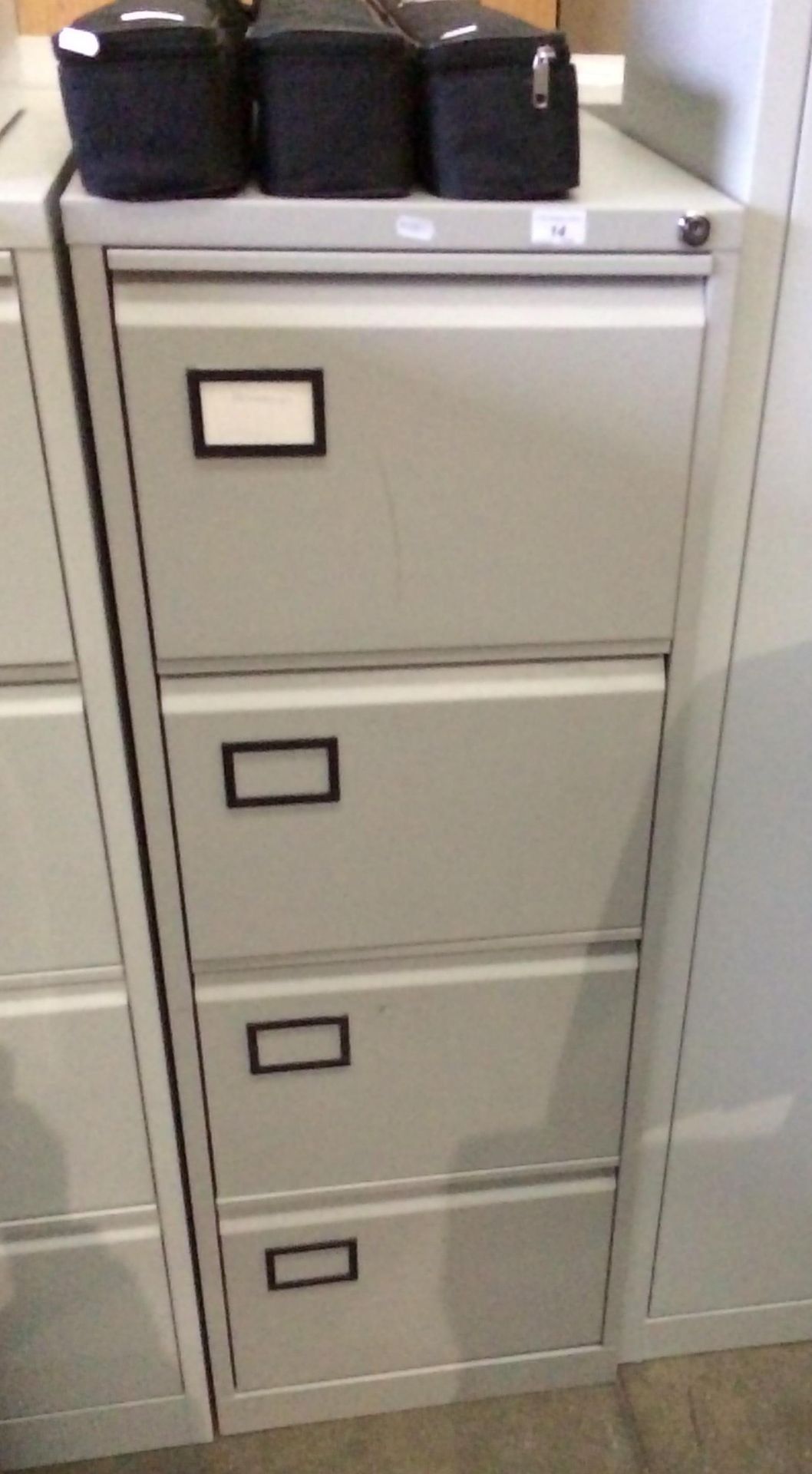 A grey metal four drawer filing cabinet (unlocked - no key)