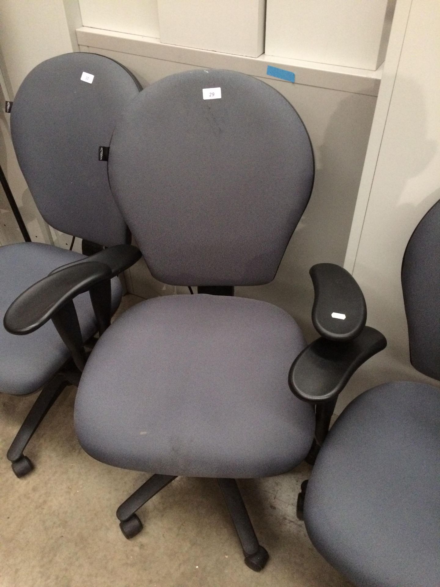 A grey upholstered office swivel armchair