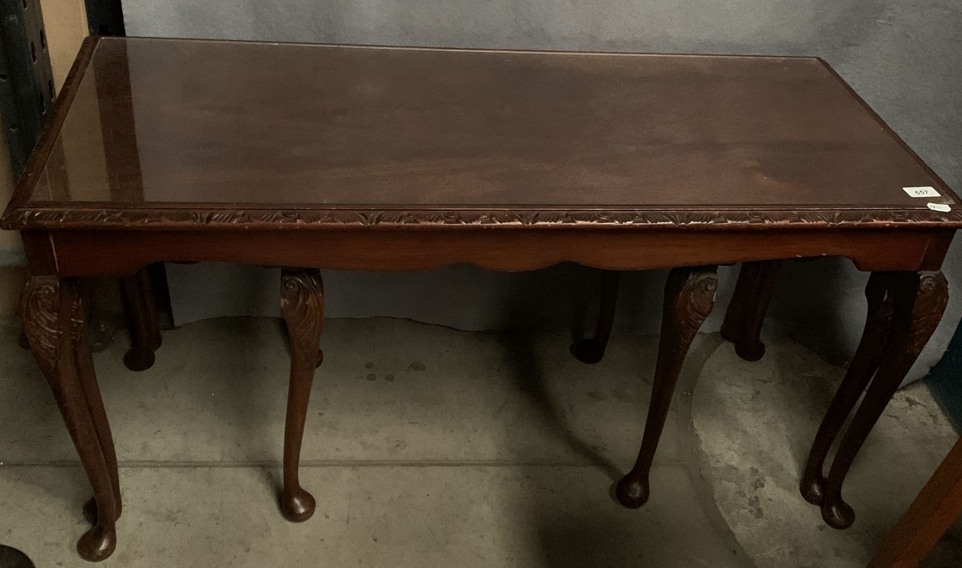 A mahogany nest of three coffee tables with glazed tops