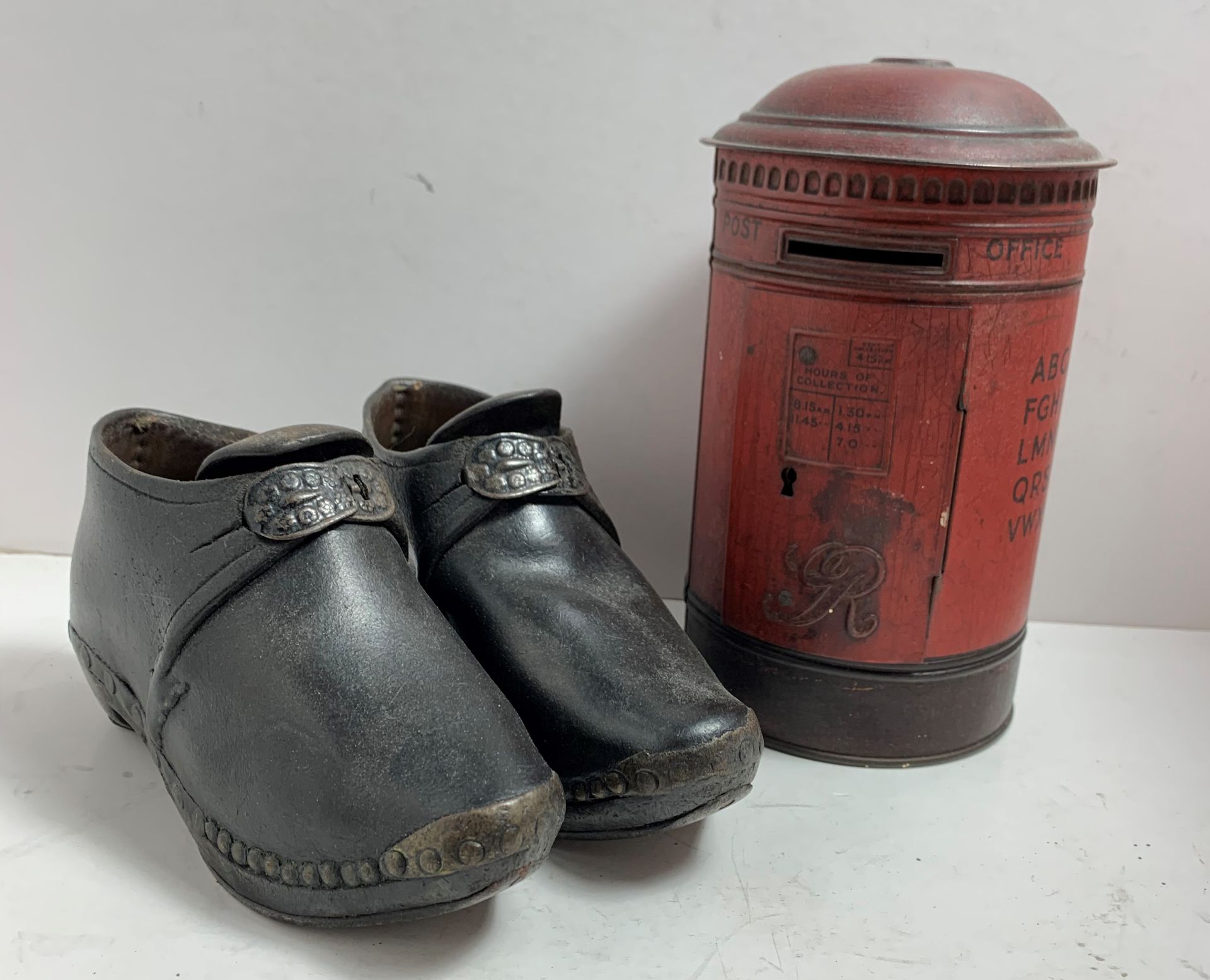 A tin plate post box money box and a pair of children's wood and leather clogs with metal buckles