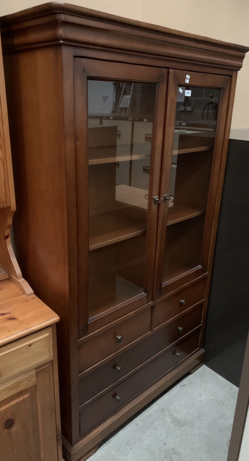 A wood finish wall unit with two glazed doors over three drawers 101 x 172cm