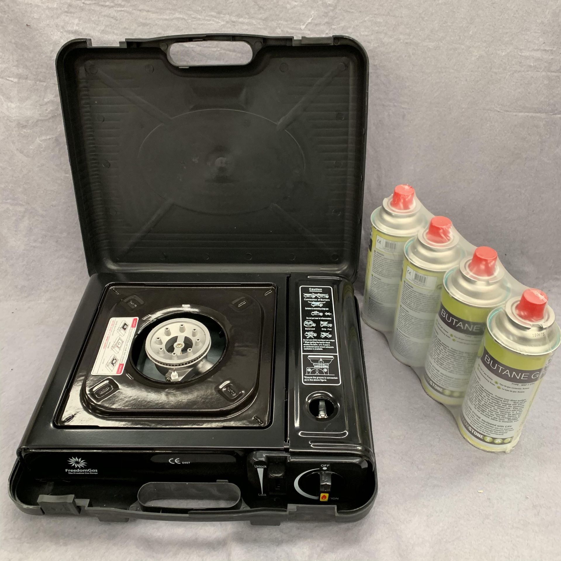 A Freedom Gas portable gas camping stove and four canisters of butane gas