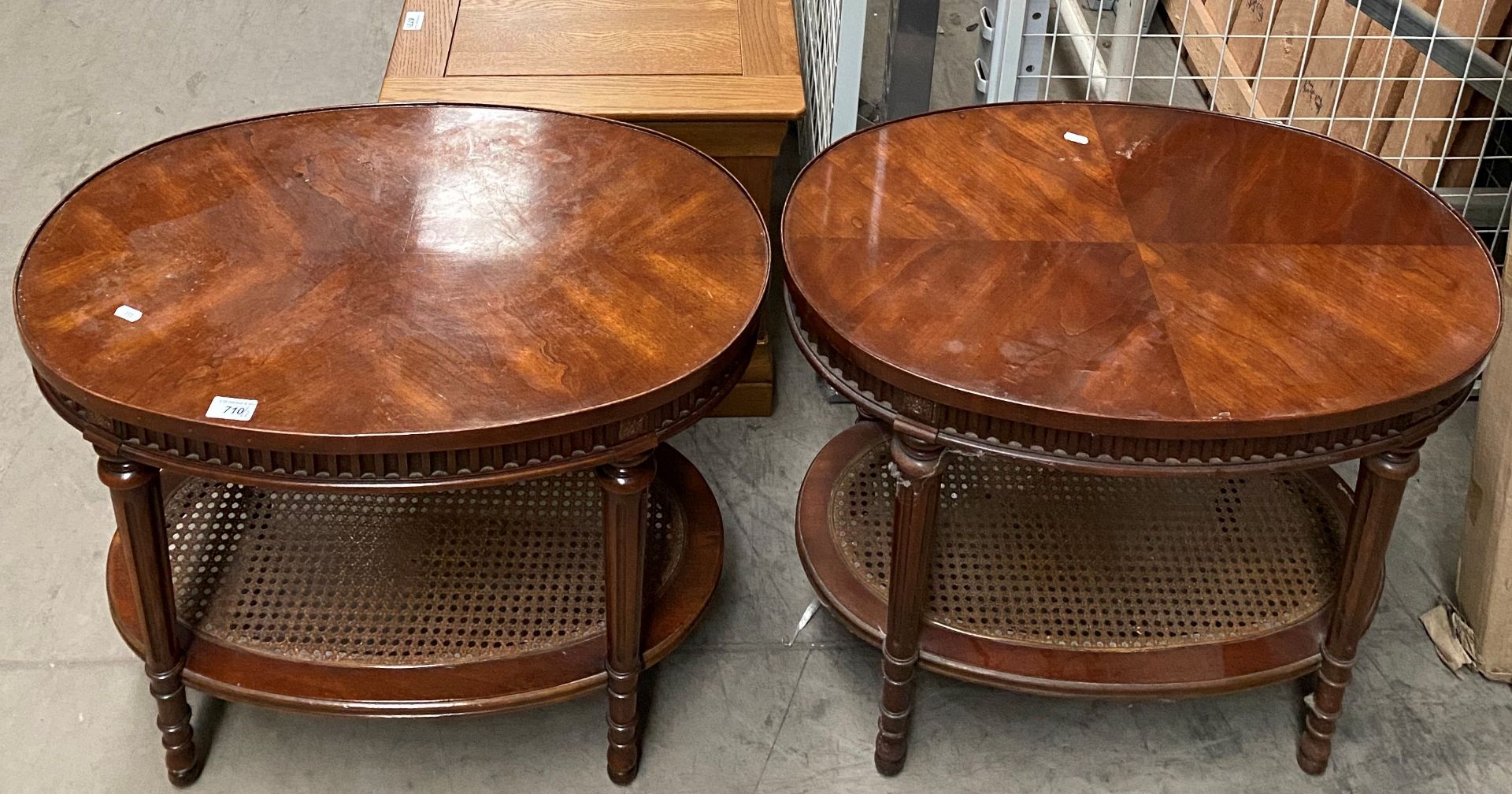 A pair of mahogany oval side tables with woven under trays,