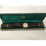 A 9ct gold wrist watch with brown leather strap