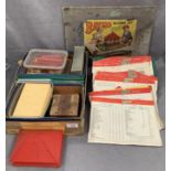 A box containing Bayko building parts and three Bayko building set manuals