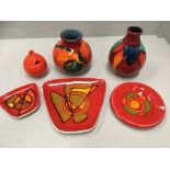 Five pieces of Poole pottery orange and brightly coloured glazed pottery and an orange glazed