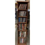 A pine CD/DVD rack and contents, containing approximately 80 CDs/DVDs, Journey, AC/DC, Brian May,