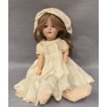 A bisque head doll marked MOA Made in Germany Welsch 150,
