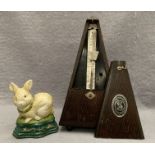 An oak cased metronome and a small cast iron rabbit doorstop