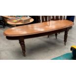 A Victorian mahogany slender oval dining table/bay window table on turned legs with castors,