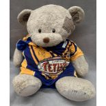 A Leeds Rhinos 'Tetleys' Patrick rugby league top with signatures, on a soft toy bear,